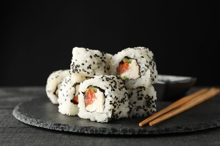 Tray with delicious sushi rolls, close up